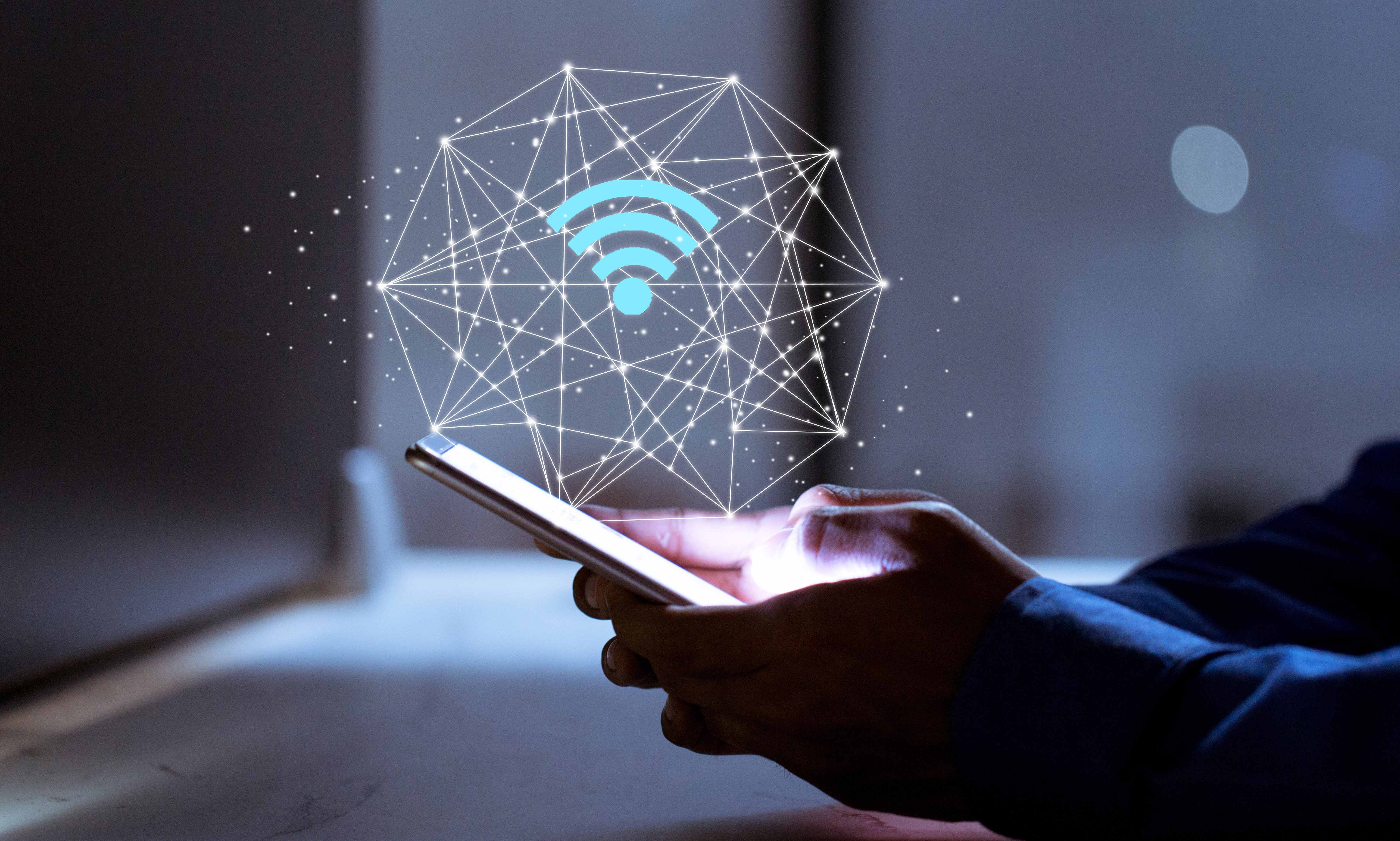 man holding phone with wi-fi icon