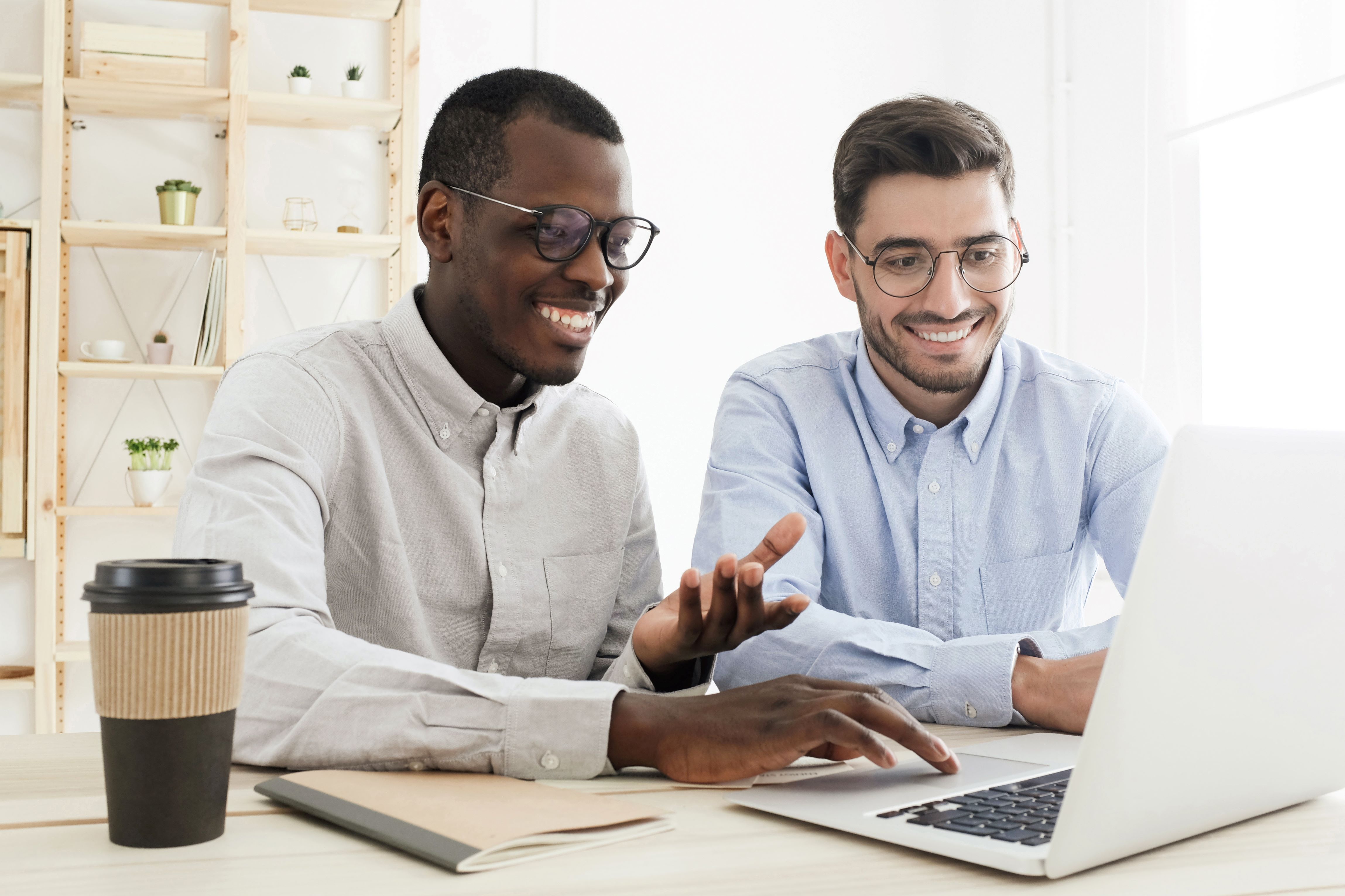 two people smiling while studying 5G on their laptop