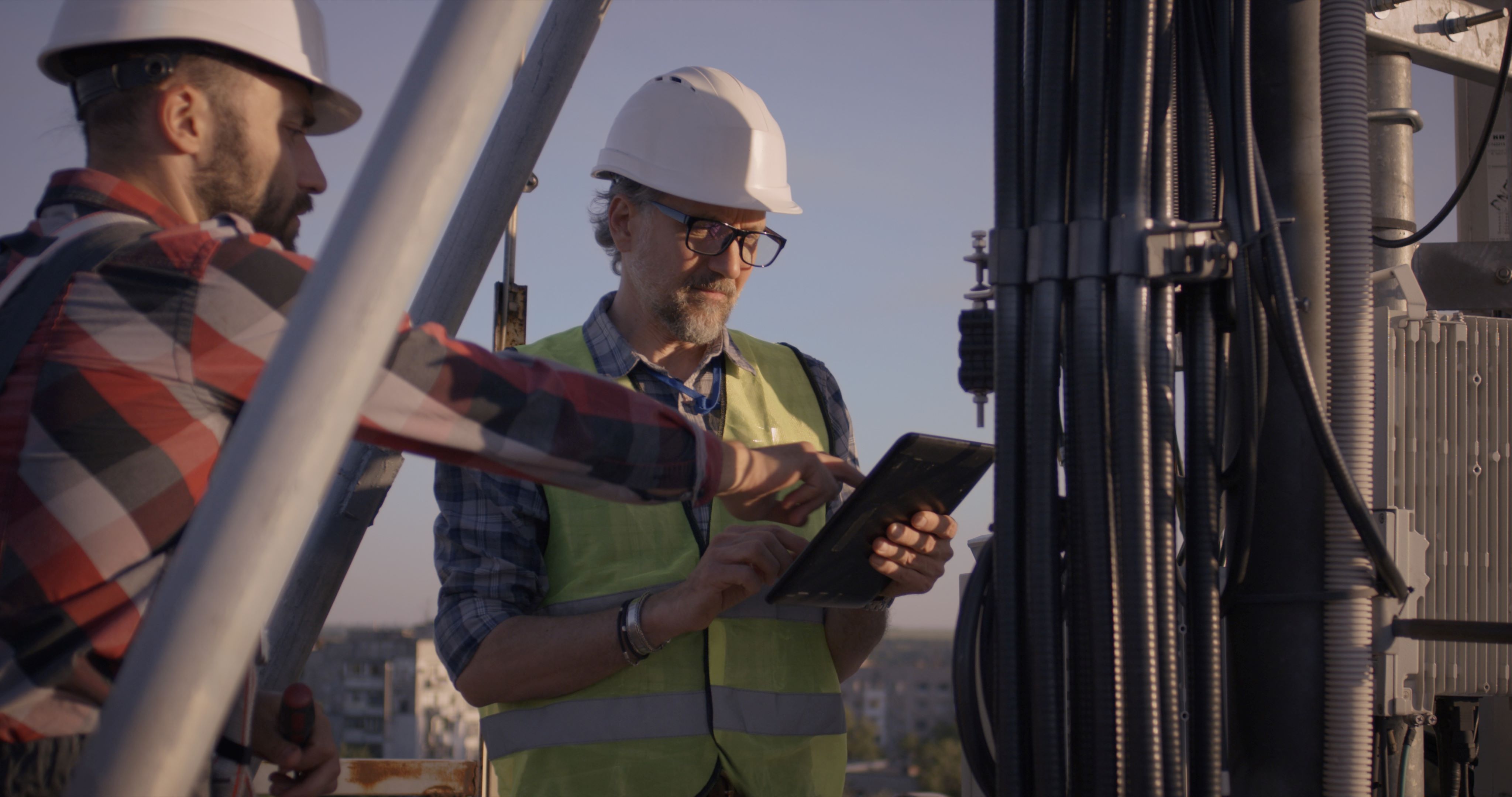 two 5G engineers working on a cell tower