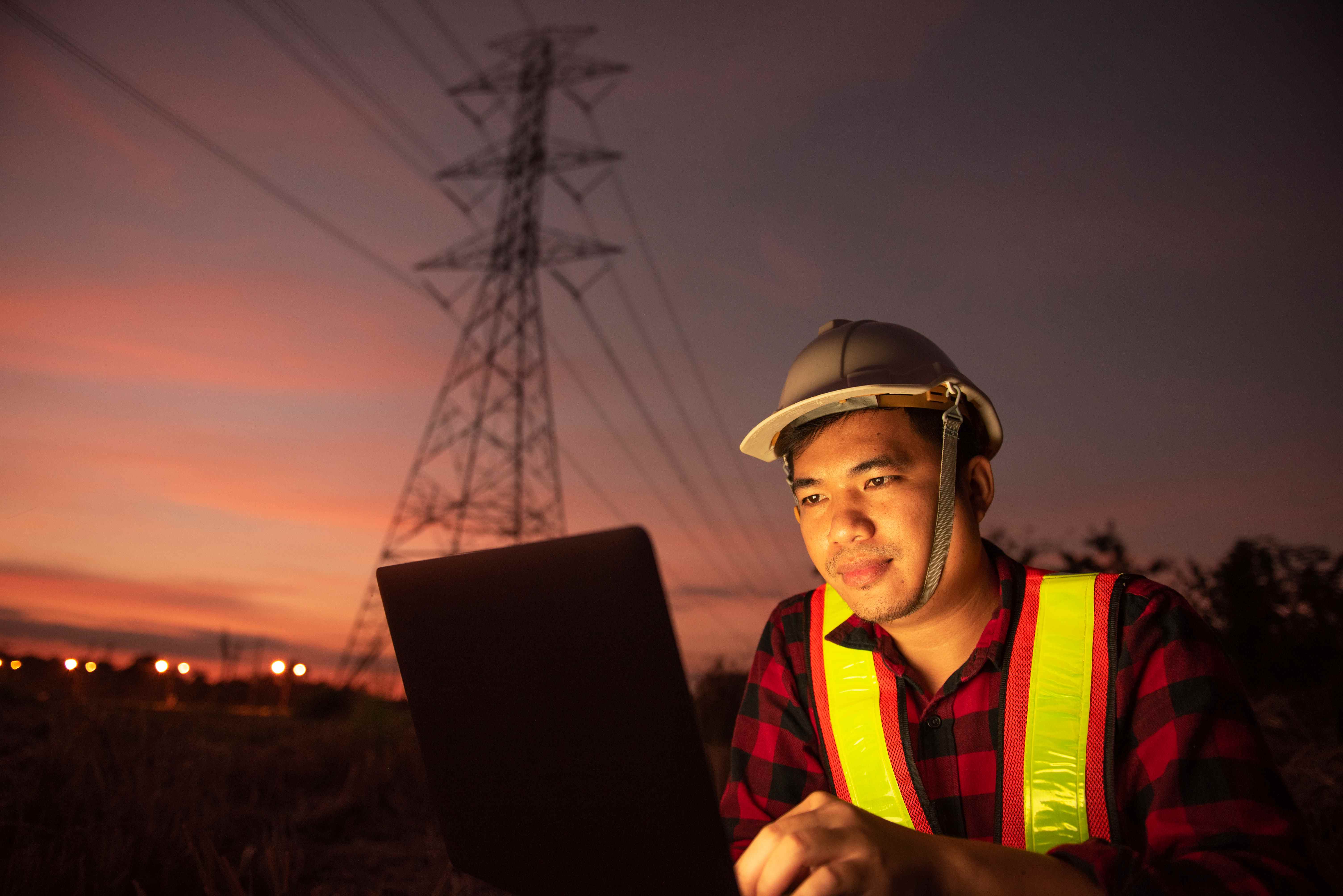 man in sunset near cell tower performing 5G troubleshooting